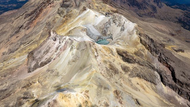 Cima del Iztaccíhuatl con su glaciar y una laguna turquesa, vista desde el aire