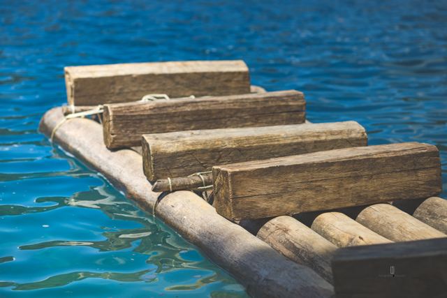 Balsa de troncos de cerca sobre agua azul