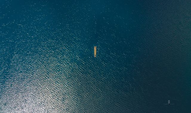 Balsa diminuta en una laguna, vista desde muy arriba