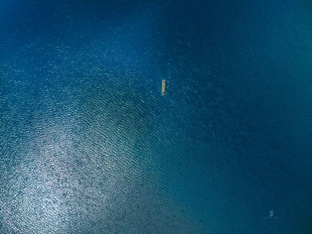 Balsa en medio del agua azul, vista aérea
