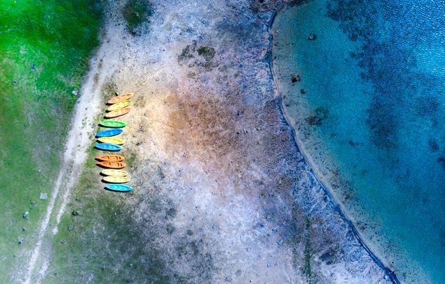 Kayaks de colores en la orilla de una laguna, vista aérea