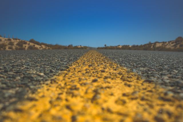 Carretera con línea amarilla en el desierto, a ras del suelo