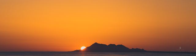 Atardecer naranja sobre una sierra en el horizonte