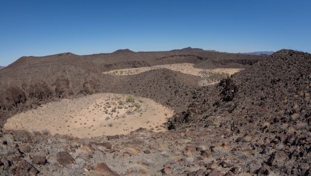 Hondonadas de arena entre roca oscura