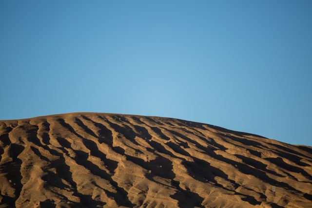 Duna con ondas de arena bajo el cielo azul