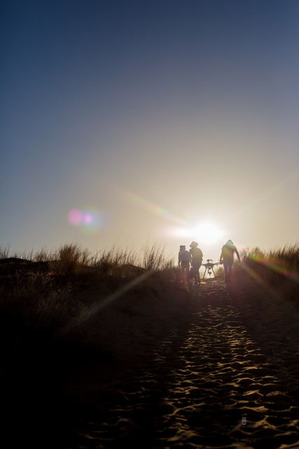 Personas caminando a contraluz en el desierto