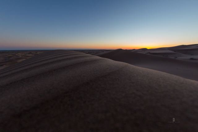 Duna al atardecer con el horizonte encendido