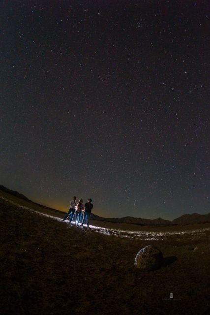Personas con linternas bajo el cielo estrellado
