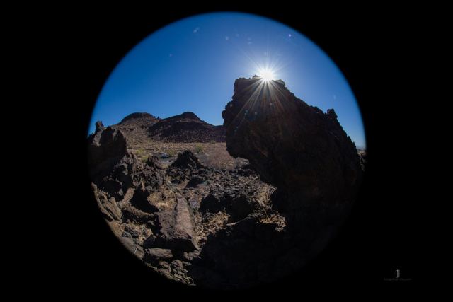 Rocas volcánicas y el sol con lente ojo de pez
