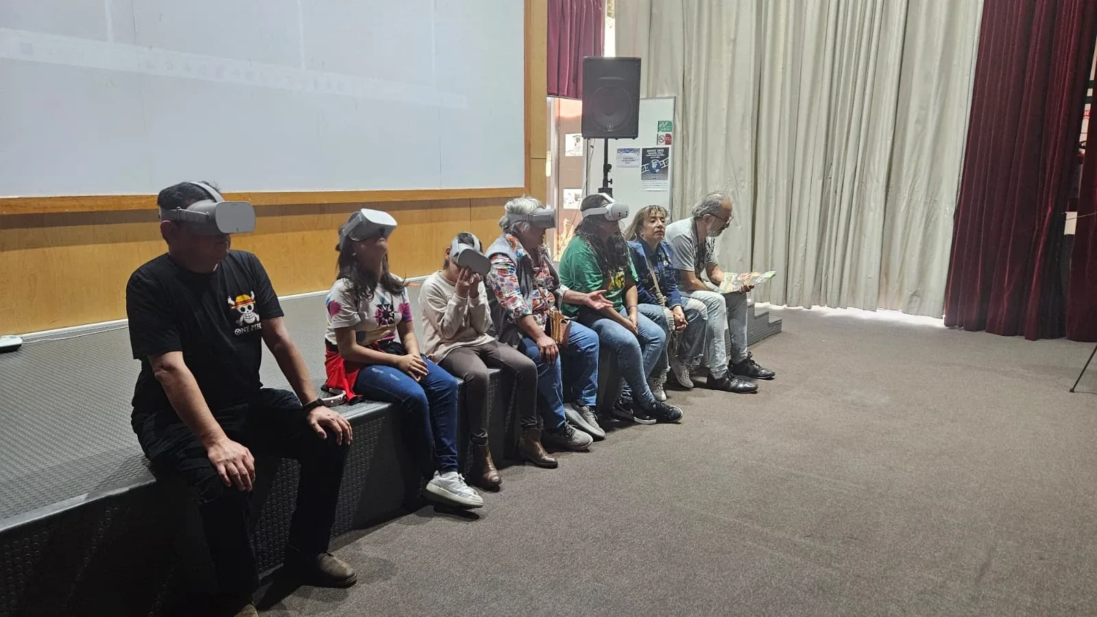 Un grupo de participantes comparte una experiencia con visores en un auditorio.